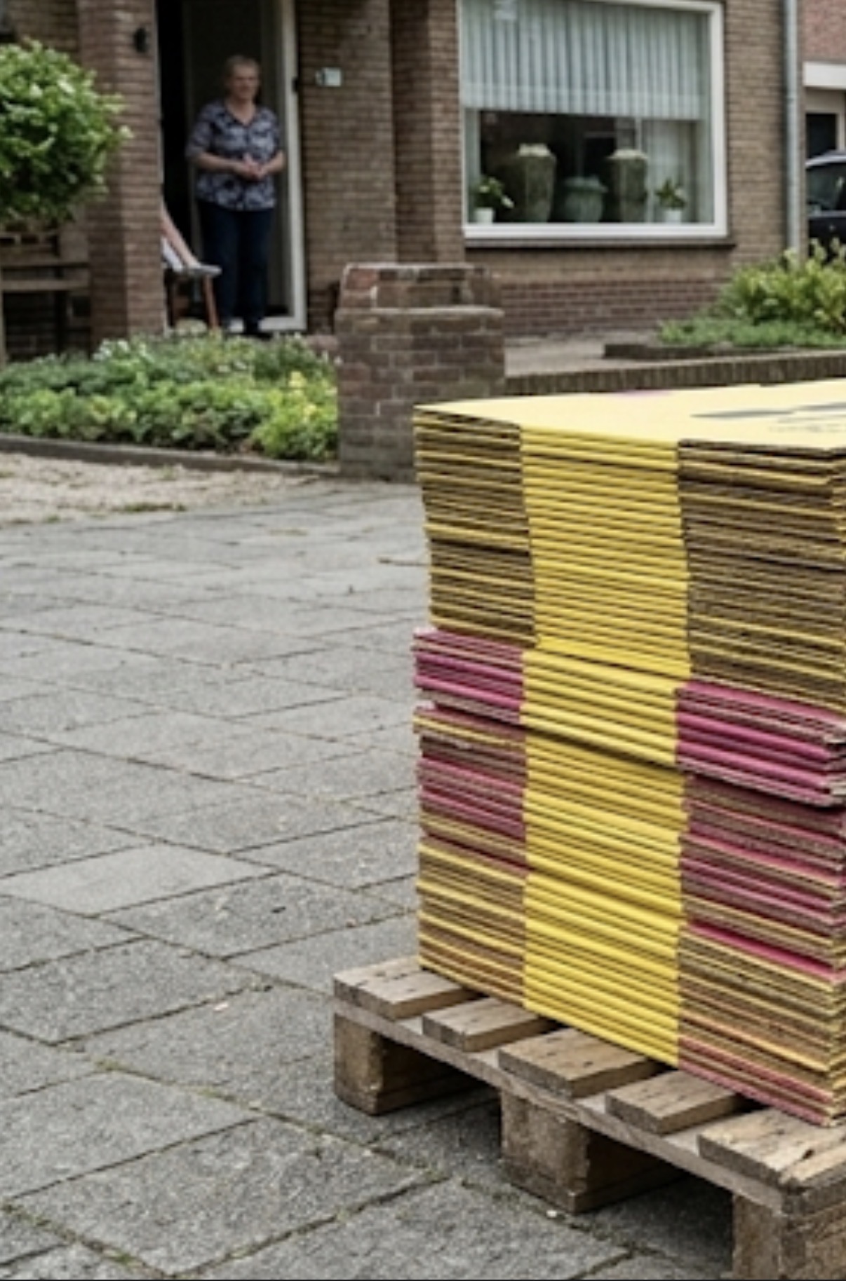Pallet vol platgevouwen gele en roze Deel-Doos verhuisdozen klaar voor ophaling